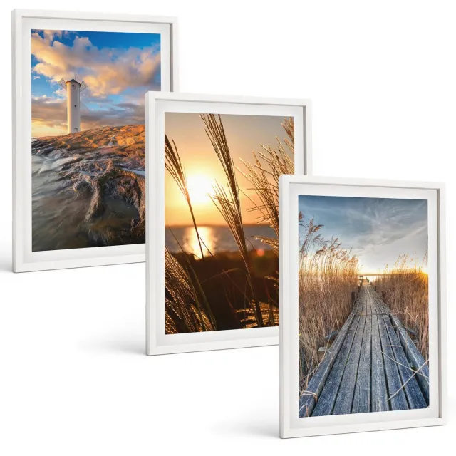 TULUP 3-Delige Schilderij Set - Uitzicht op de vuurtoren over de zee, het gras en een houten pier. - 40x60 - Moderne Wanddecoratie - Woonkamer - Muurdecoratie Witte lijst